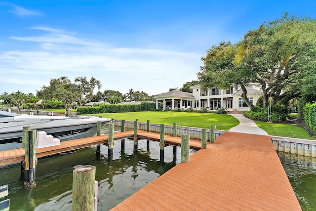 view of dock featuring a water view and a yard