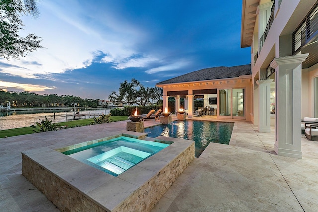 13209 Rolling Green Rd, North Palm Beach, FL 33408 - pool at dusk featuring an in-ground hot tub, a patio area, and an outdoor pool