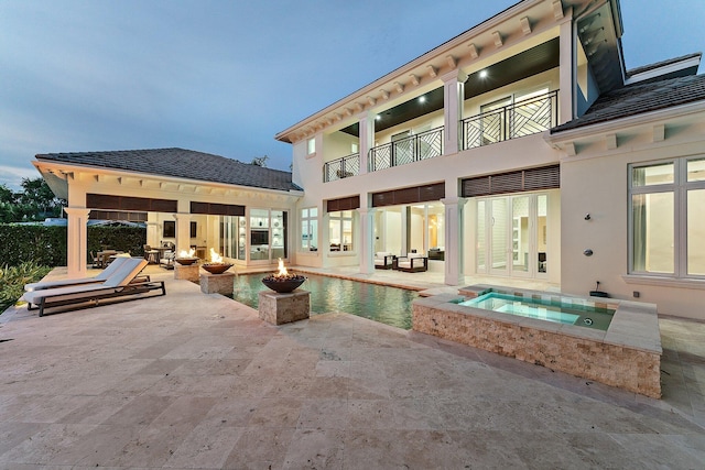 13209 Rolling Green Rd, North Palm Beach, FL 33408 - back of house with an in-ground hot tub, a patio area, a fire pit, an outdoor pool, and stucco siding