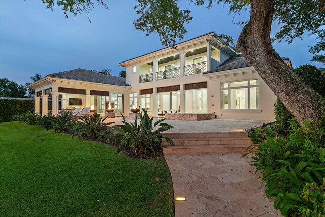 13209 Rolling Green Rd, North Palm Beach, FL 33408 - rear view of property featuring a balcony, a patio, a yard, and stucco siding
