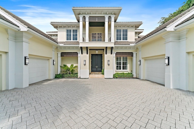 13209 Rolling Green Rd, North Palm Beach, FL 33408 - view of front of property with a balcony, stucco siding, and decorative driveway