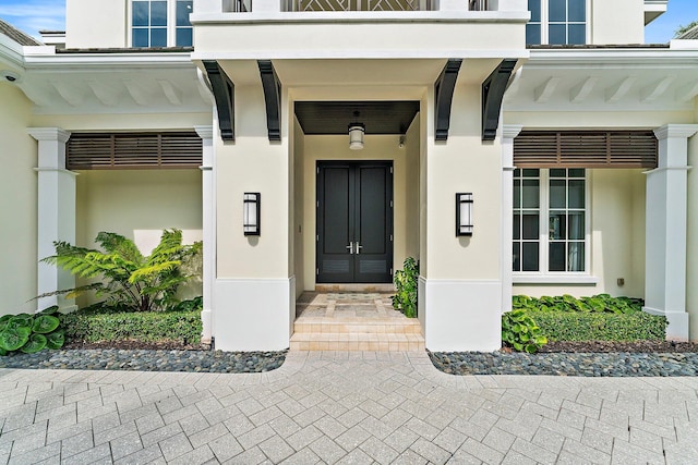 13209 Rolling Green Rd, North Palm Beach, FL 33408 - doorway to property with stucco siding and a surveillance system