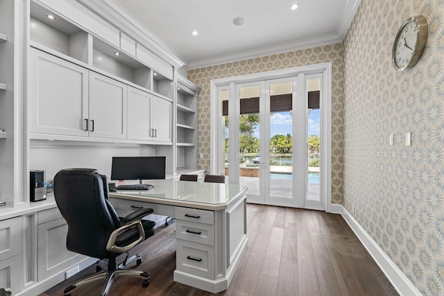 13209 Rolling Green Rd, North Palm Beach, FL 33408 - office area featuring wallpapered walls, ornamental molding, dark wood finished floors, built in desk, and baseboards