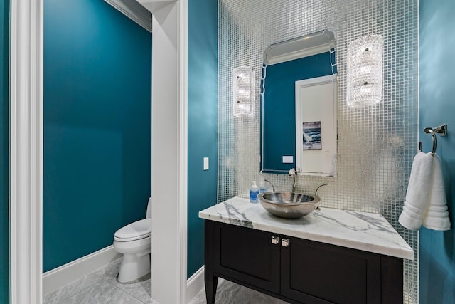 bathroom with vanity, toilet, and crown molding