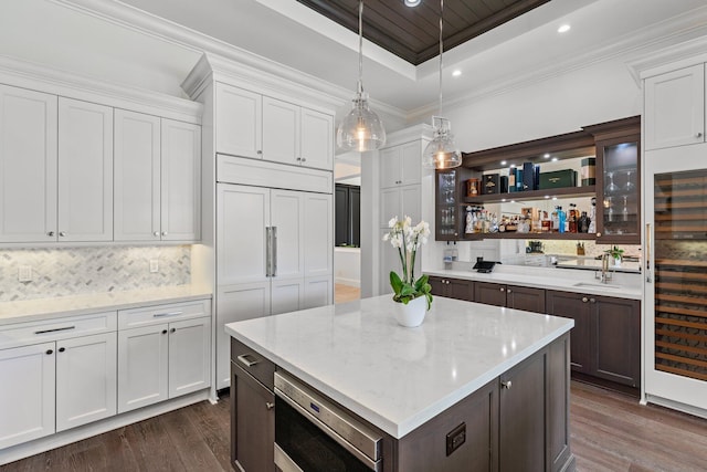 13209 Rolling Green Rd, North Palm Beach, FL 33408 - kitchen with a tray ceiling, dark wood-type flooring, white cabinets, dark brown cabinets, and hanging light fixtures