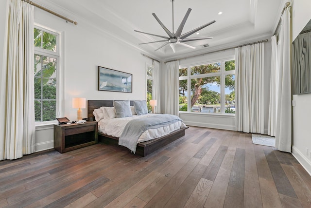 bedroom featuring multiple windows, dark hardwood / wood-style floors, and ceiling fan