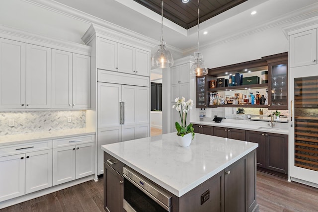 kitchen featuring dark wood-type flooring, wine cooler, white cabinetry, and dark brown cabinetry