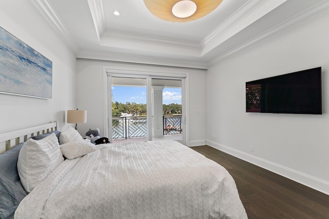 bedroom featuring dark wood-type flooring, ornamental molding, a tray ceiling, and access to exterior