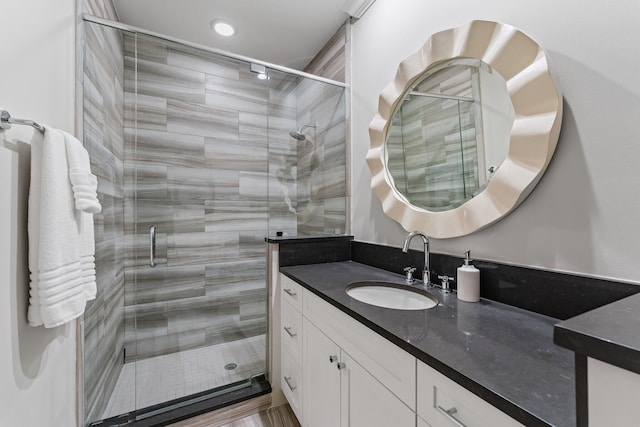 bathroom with vanity, walk in shower, and wood-type flooring