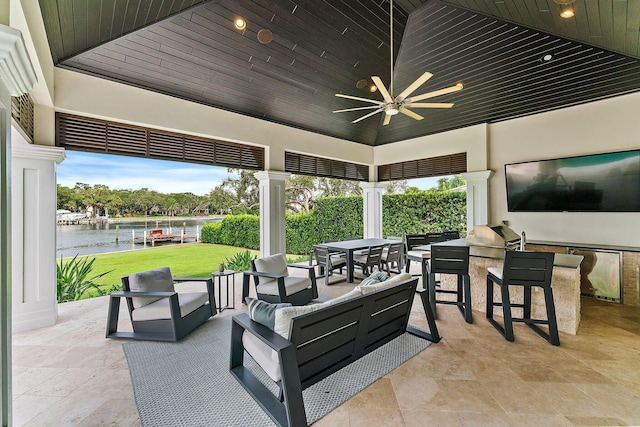 view of patio / terrace featuring an outdoor living space, exterior kitchen, a water view, and ceiling fan