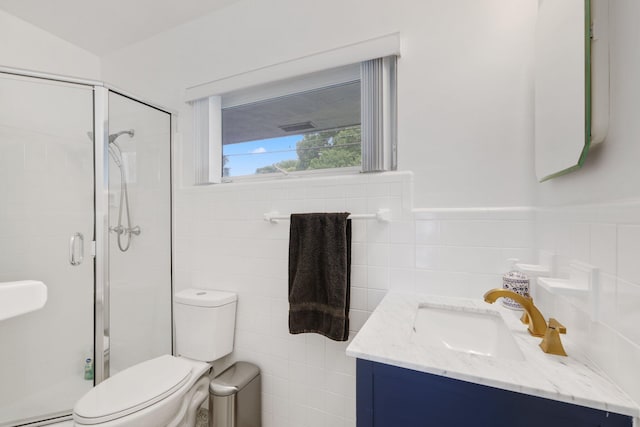 bathroom featuring backsplash, vanity, tile walls, toilet, and a shower with door