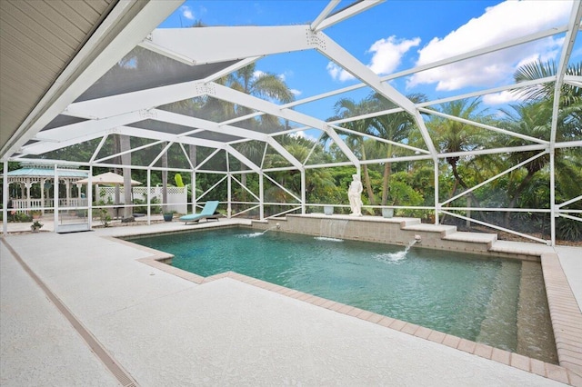 view of pool with glass enclosure, pool water feature, and a patio area