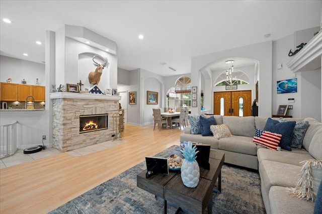 living room featuring a notable chandelier, light hardwood / wood-style flooring, and a fireplace