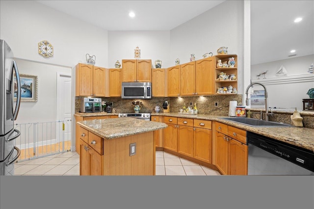 kitchen with decorative backsplash, appliances with stainless steel finishes, light stone counters, light tile patterned floors, and sink