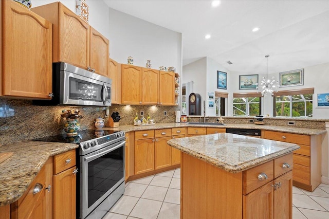 kitchen featuring stainless steel appliances, decorative backsplash, light stone counters, light tile patterned floors, and a kitchen island