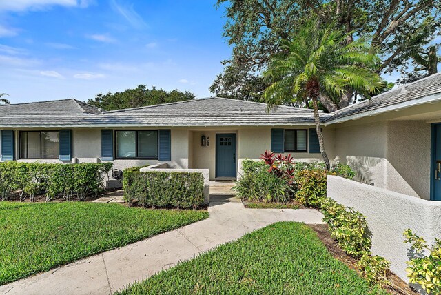 single story home with a front lawn