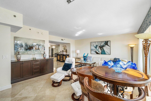 living room with a textured ceiling and light tile patterned floors