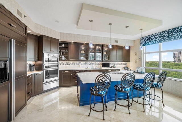 kitchen featuring decorative backsplash, refrigerator, a tray ceiling, and double oven