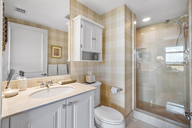 bathroom featuring toilet, walk in shower, vanity, and tile walls