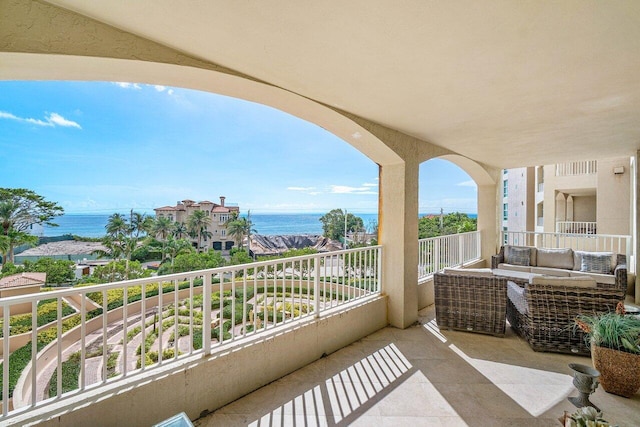 balcony featuring an outdoor living space and a water view