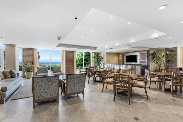 dining room with expansive windows, a tray ceiling, and light tile patterned floors