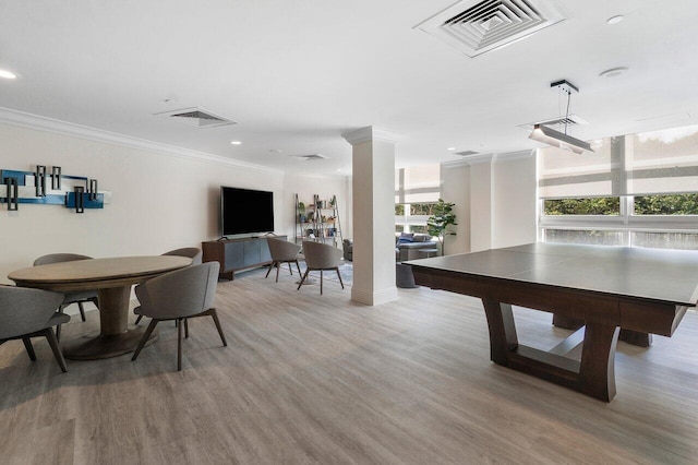 rec room featuring light wood-type flooring, decorative columns, and crown molding