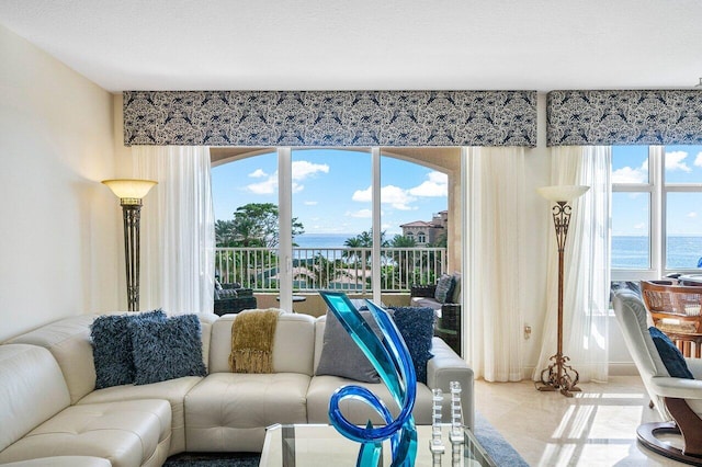 tiled living room with a textured ceiling and a water view