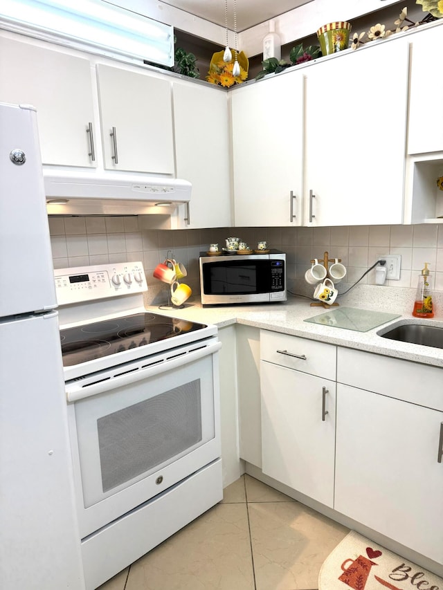 kitchen with backsplash, white appliances, sink, light tile patterned floors, and white cabinetry