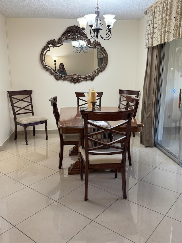 tiled dining area with a notable chandelier and a textured ceiling