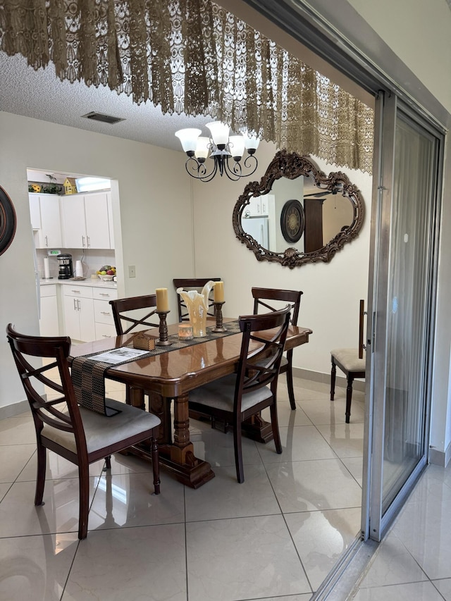 dining area with light tile patterned floors and an inviting chandelier