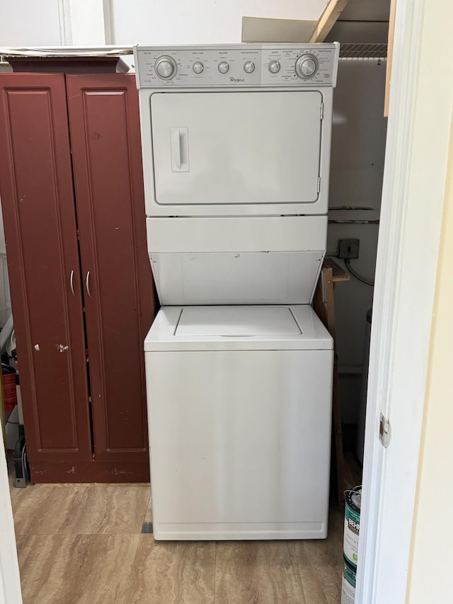 washroom featuring cabinets and stacked washer and dryer