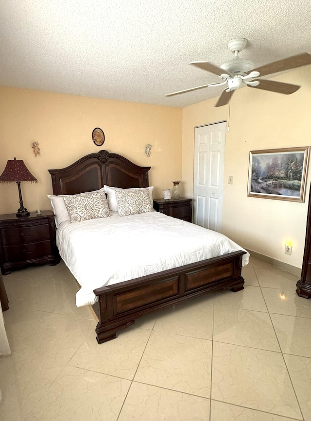 tiled bedroom with a textured ceiling, a closet, and ceiling fan