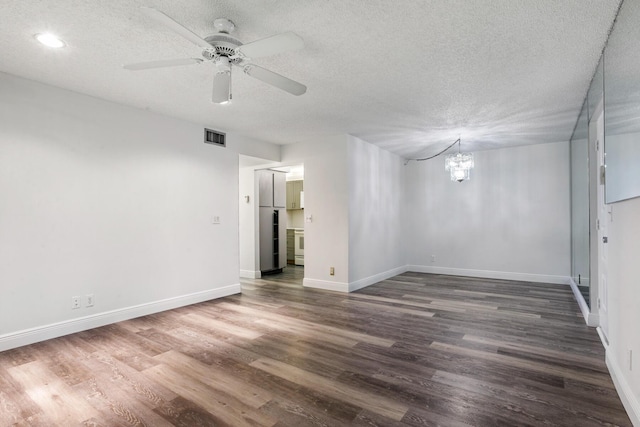 empty room with visible vents, ceiling fan with notable chandelier, a textured ceiling, wood finished floors, and baseboards