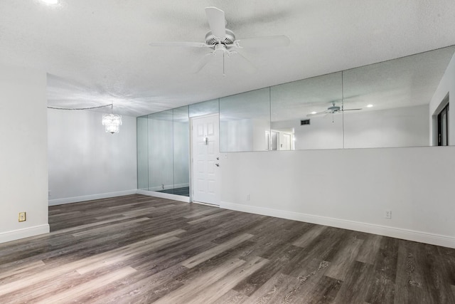 spare room featuring a textured ceiling, wood finished floors, baseboards, and ceiling fan