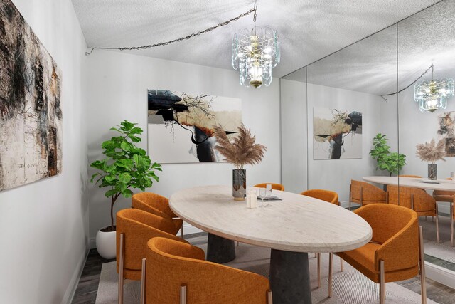 dining space featuring hardwood / wood-style floors, a chandelier, and a textured ceiling