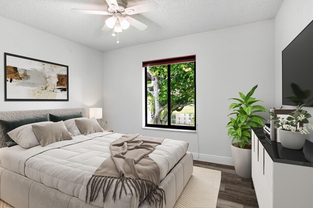 bedroom with dark hardwood / wood-style flooring, ceiling fan, and a textured ceiling