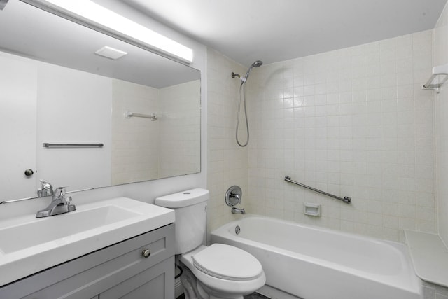 full bathroom featuring tiled shower / bath, vanity, and toilet