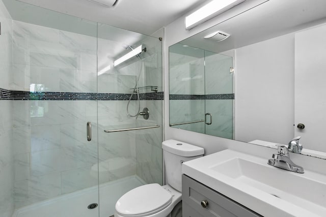 bathroom featuring vanity, toilet, and a shower with door