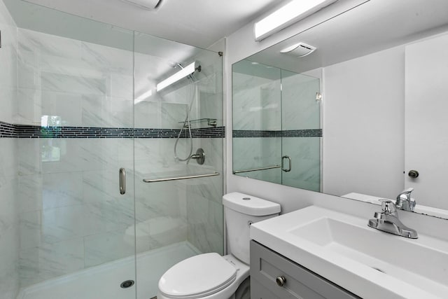 full bathroom featuring vanity, toilet, and a shower stall