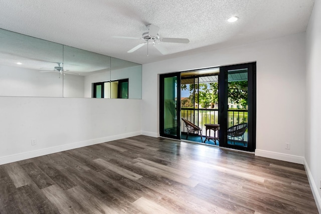 empty room with baseboards, a textured ceiling, and wood finished floors