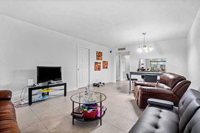 tiled living room with sink, a textured ceiling, and a chandelier