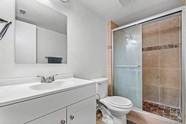 bathroom with vanity, a shower with shower door, a textured ceiling, and toilet