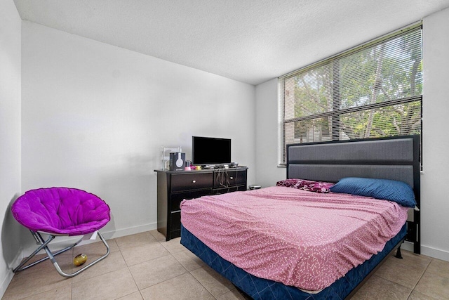 bedroom featuring light tile patterned flooring and a textured ceiling