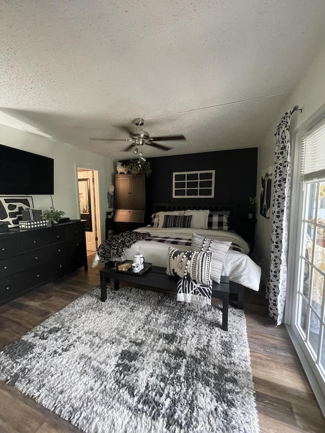 bedroom with a textured ceiling, dark hardwood / wood-style floors, and ceiling fan