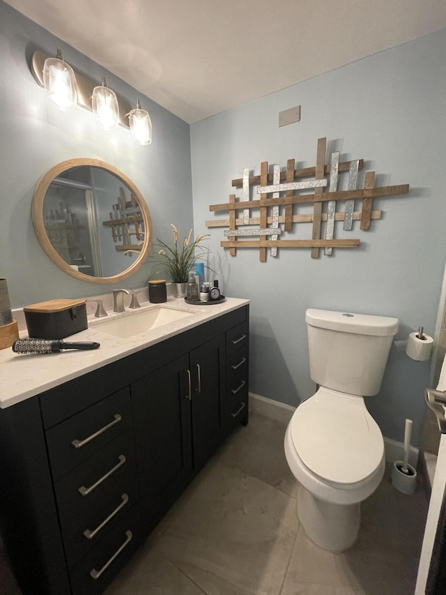 bathroom with toilet, tile patterned floors, and vanity