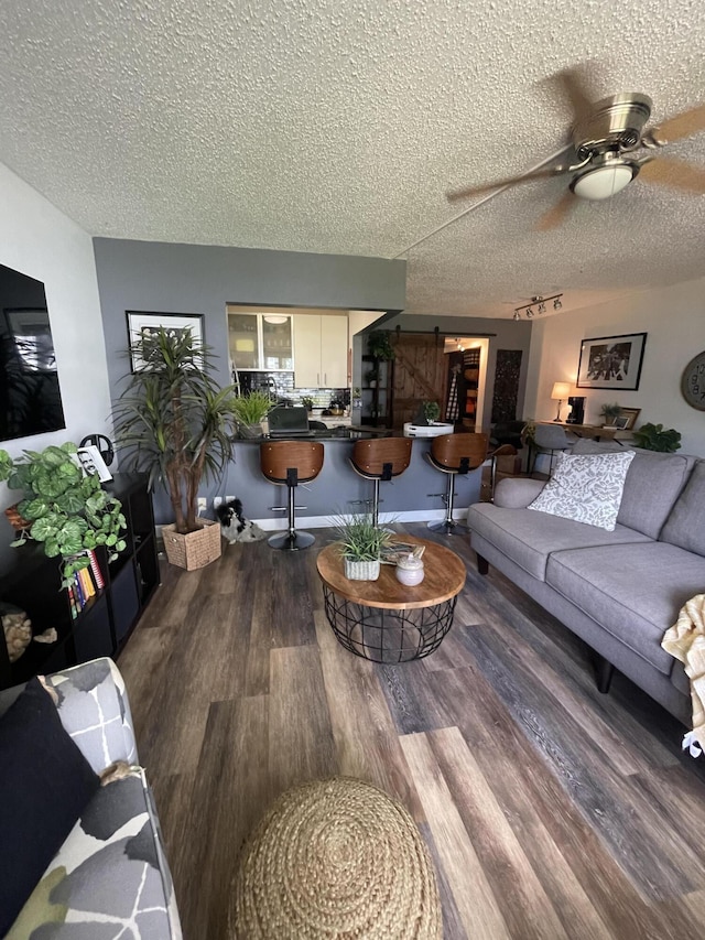 living room featuring ceiling fan, a textured ceiling, and hardwood / wood-style floors