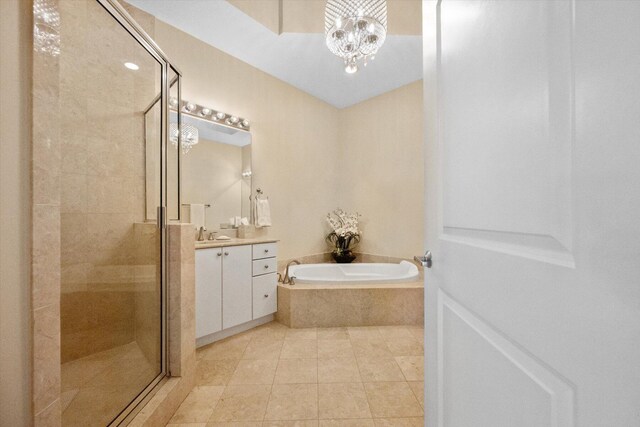 bathroom with tile patterned flooring, separate shower and tub, vanity, and a chandelier