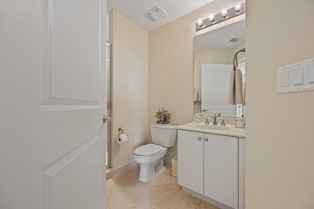 bathroom featuring tile patterned floors, vanity, walk in shower, and toilet