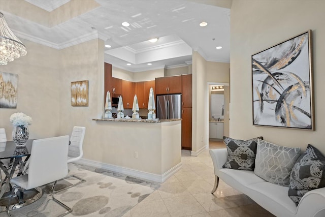 interior space with crown molding, a tray ceiling, light tile patterned floors, stainless steel fridge, and kitchen peninsula