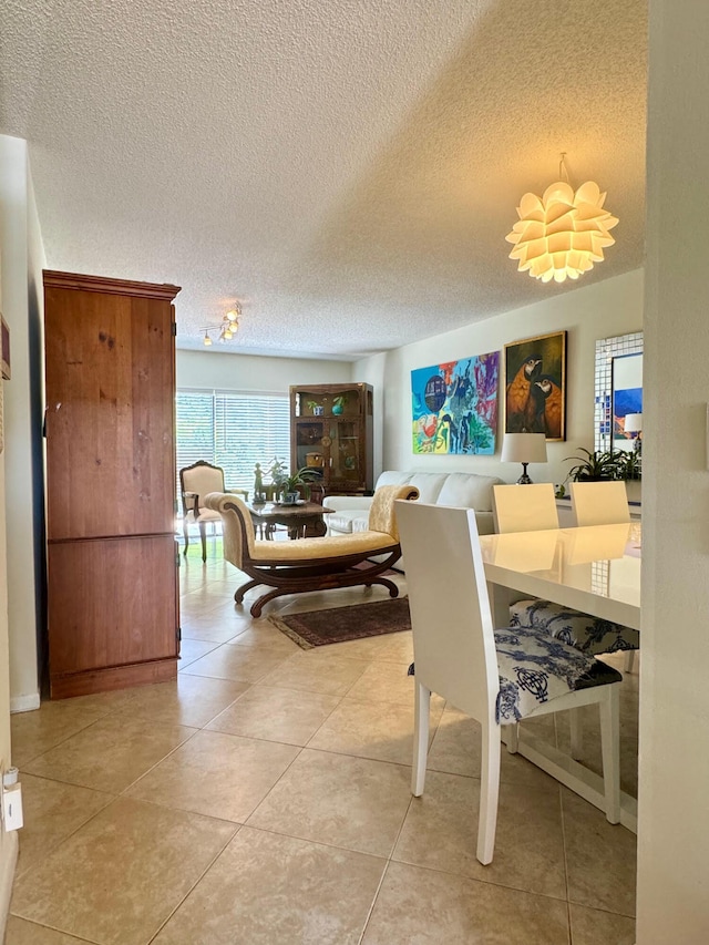 tiled dining area featuring a textured ceiling and an inviting chandelier